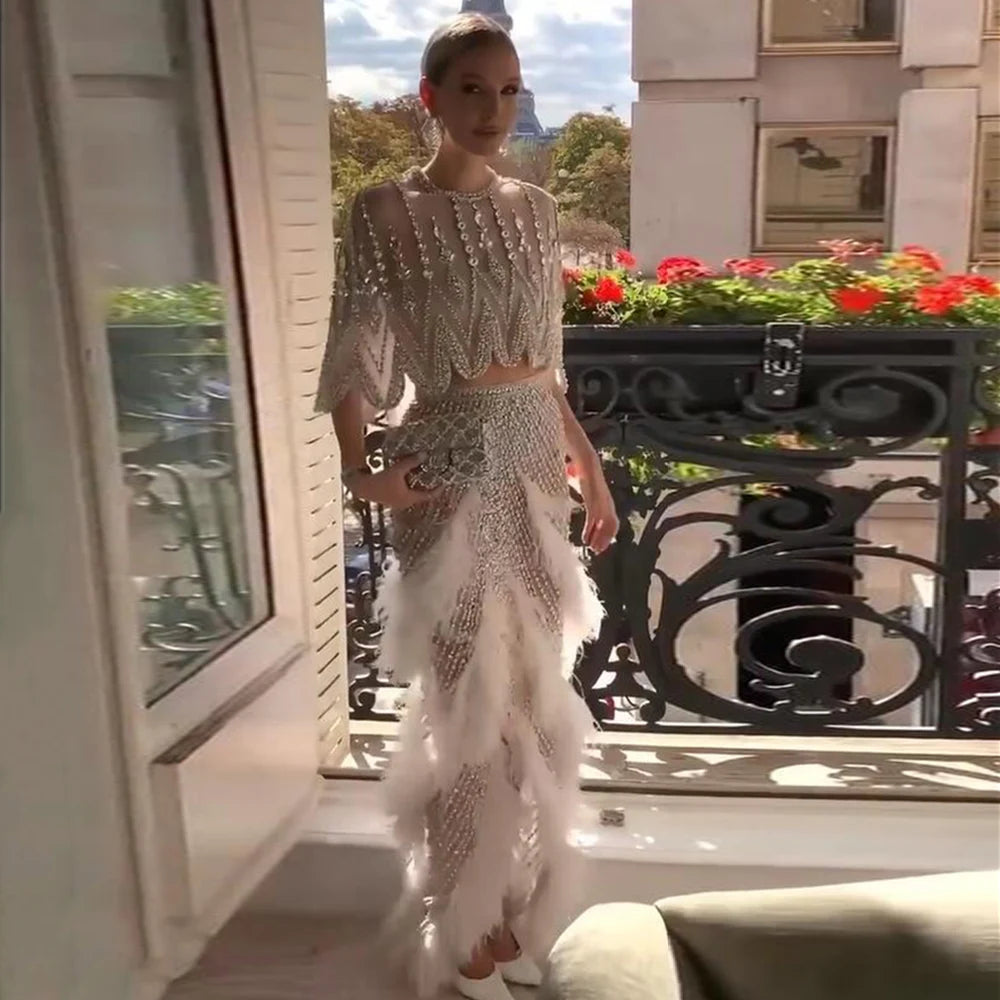 Designer-style white feather gown with embellished bodice and glamorous fitted silhouette