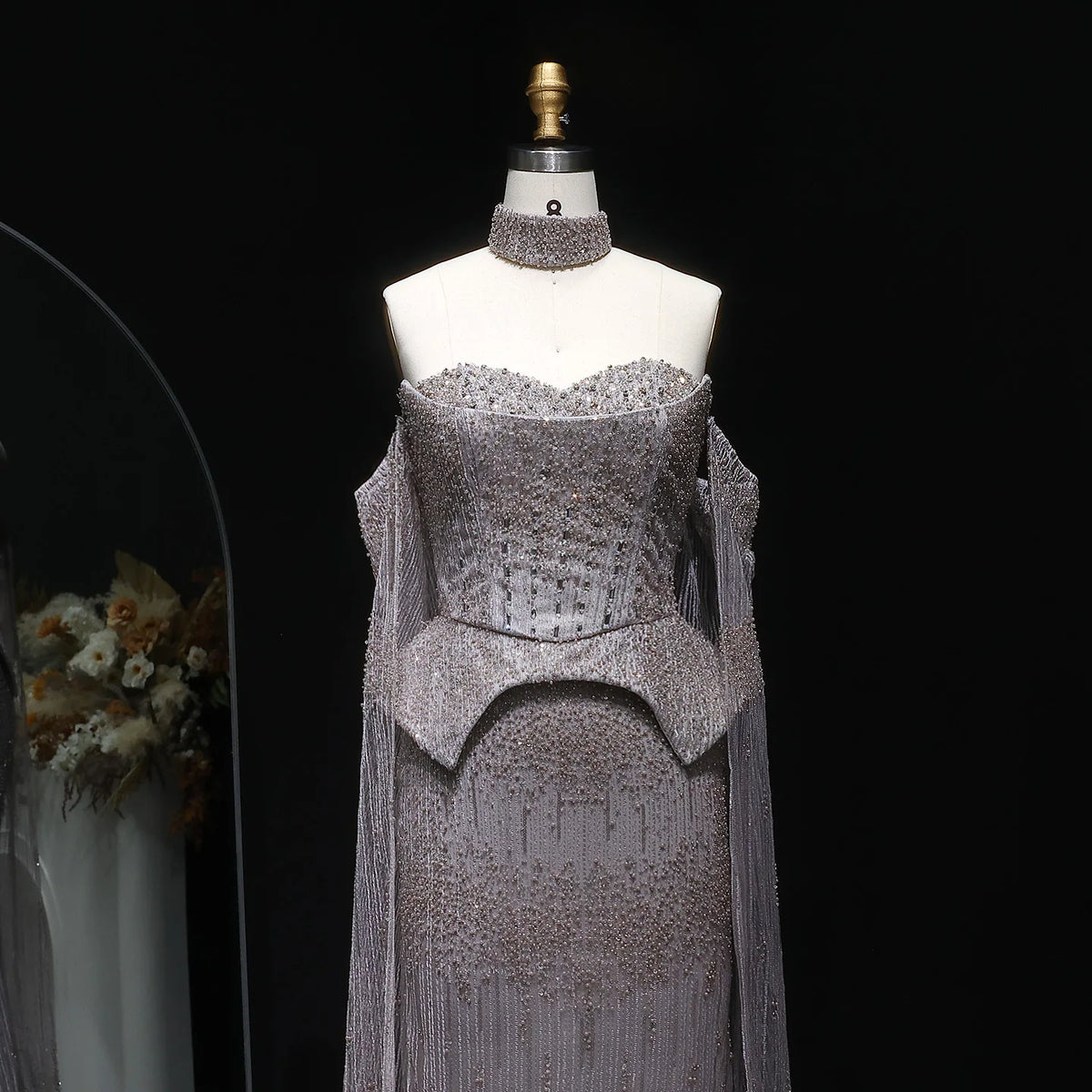 Close-up of silver formal gown with intricate crystal beading and sequin embellishment