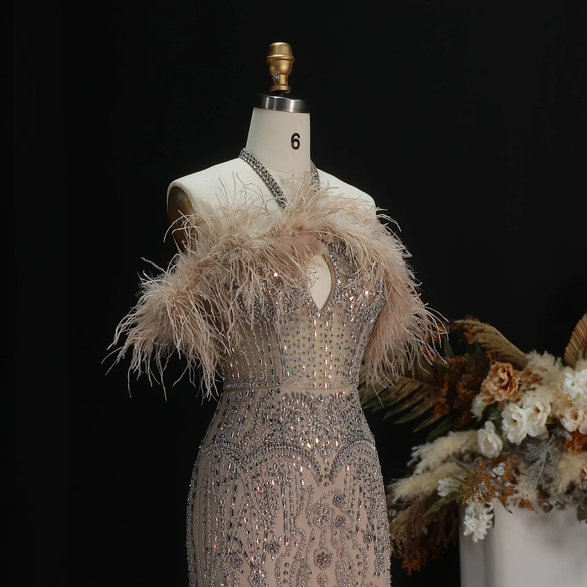 Champagne statement evening gown with wispy feathers and sparkling beadwork