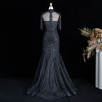 Back view of black crystal embellished mermaid evening gown with tulle skirt