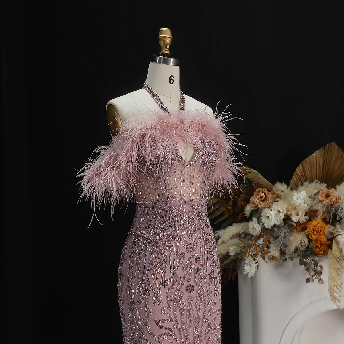 Pink floor-length formal gown with all-over beading and feather neckline